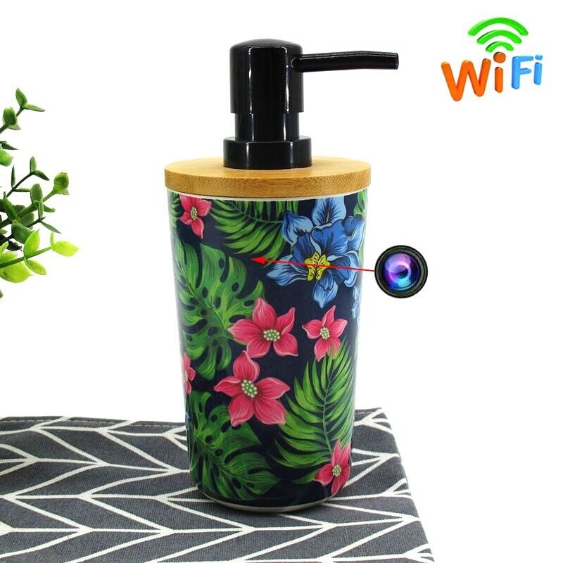 The Cute Decorative Display SpyCam is a soap dispenser with a charming tropical floral design, a hidden camera lens, and WiFi capability, resting on a patterned surface beside a plant. It offers both decorative appeal and 1080P video recording.