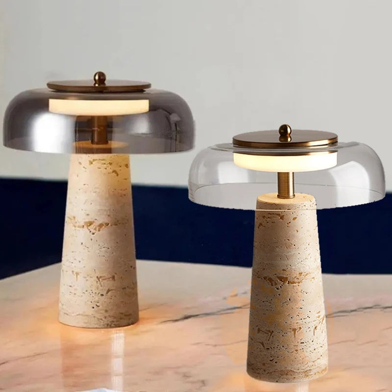 Two Mushroom Desk Lamps with conical stone bases and round glass shades, inspired by the clean lines of Organic Lighting, are placed on a marble surface against a neutral background.