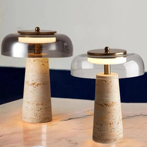 Two Mushroom Desk Lamps with conical stone bases and round glass shades, inspired by the clean lines of Organic Lighting, are placed on a marble surface against a neutral background.