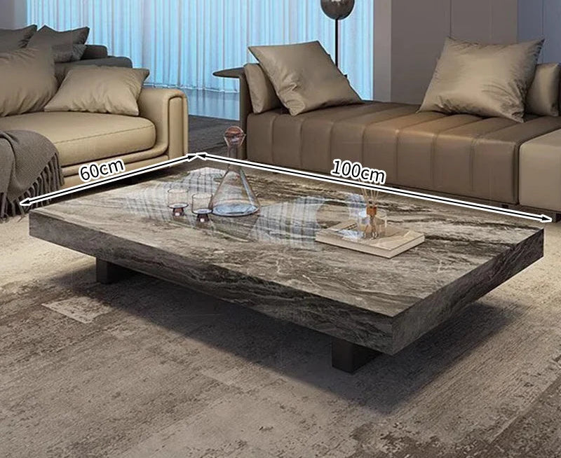 The Modern Luxe Coffee Table, a rectangular minimalist piece measuring 100 cm by 60 cm, is placed in a modern living room between two sofas and perfectly complements contemporary interiors.