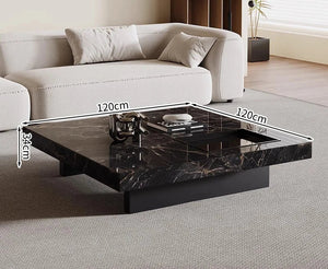 The Modern Luxe Coffee Table, a square black marble minimalist piece measuring 120 x 120 x 34 cm, sits in front of a light-colored sofa—perfect for modern interiors.