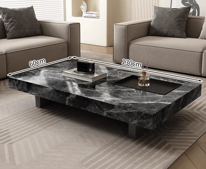 The Modern Luxe Coffee Table, a minimalist black marble piece measuring 130 cm by 60 cm, sits between two beige sofas, bringing elegance to modern living room interiors.