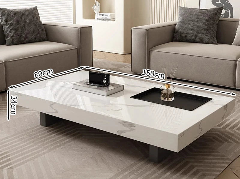 The Modern Luxe Coffee Table (150x80x34 cm) sits between two grey sofas in a living room, perfectly complementing modern interiors with its minimalist design.