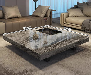 The Modern Luxe Coffee Table is a square marble table with a central tray, measuring 80 cm x 80 cm—ideal for modern living rooms and perfectly placed on a rug.