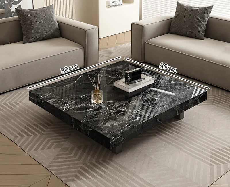 The Modern Luxe Coffee Table, a square black marble minimalist piece measuring 80 cm per side, is placed between two beige sofas in a modern living room.