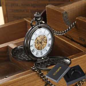 The Vintage Mechanical Pocket Watch, featuring visible gears and Roman numerals, rests in a wooden box with a black "GORBEN" branded watch box beside it.