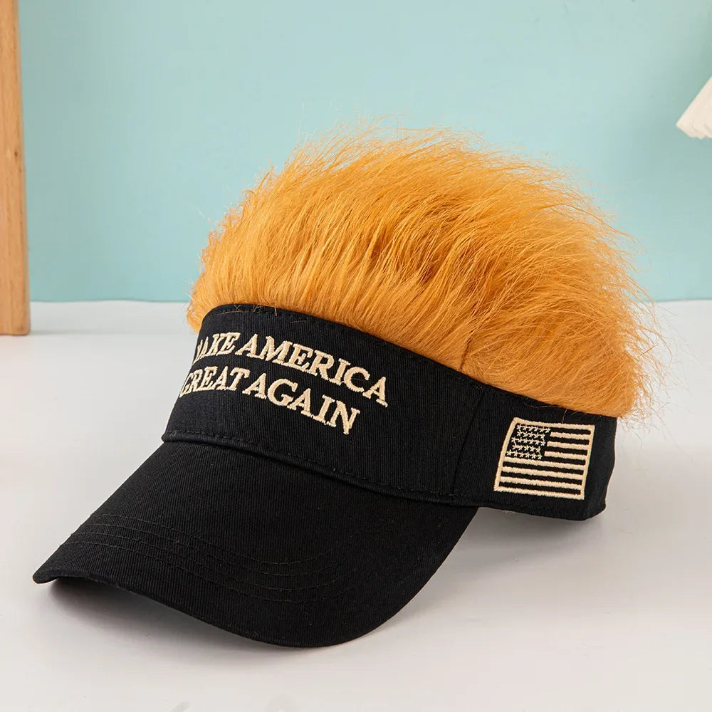 The Visor Cap - Make America Great Again is a black patriotic cap with "MAKE AMERICA GREAT AGAIN" text, an embroidered American flag, and fun orange faux hair on top, displayed on a white surface.
