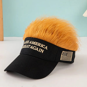 The Visor Cap - Make America Great Again is a black patriotic cap with "MAKE AMERICA GREAT AGAIN" text, an embroidered American flag, and fun orange faux hair on top, displayed on a white surface.