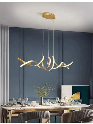 A modern dining room showcases a Stylish Pendant Light as an abstract, sculptural chandelier above a large table with dinnerware, gray upholstered chairs, and blue paneled walls.