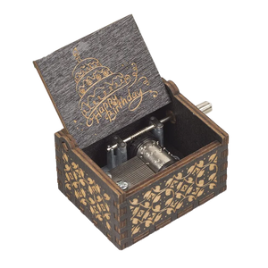 The Happy Birthday Music Box is a wooden music box with ornate carvings and an open lid that features a "Happy Birthday" message and cake illustration, making it the perfect birthday gift. The design exposes the intricate internal music mechanism.