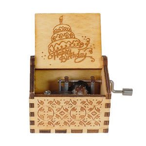 The Happy Birthday Music Box is a delightful wooden music box with the lid open, showcasing a "Happy Birthday" message and an engraved cake. This charming music box features a hand crank on the side and intricate exterior carvings, making it the perfect birthday gift.