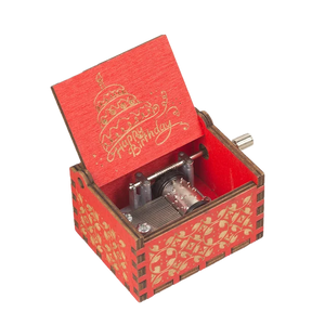 A small red wooden "Happy Birthday Music Box" with a wind-up mechanism, perfect as a gift. The inside of the lid features a "Happy Birthday" message and a cake illustration.