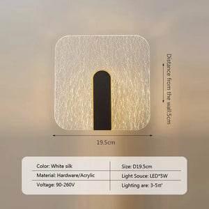 The Beautiful Wall Sconce is a modern luxury wall lamp featuring a white silk-colored finish and vertical central design. Measuring 19.5 cm by 19.5 cm with a 5 cm wall distance, this elegant light uses a 5W LED that perfectly illuminates spaces of 3-5 square meters.