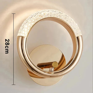 The Luxury Wall Sconce is a modern and stylish LED wall light with a circular, gold-colored design. It features a textured, illuminated top section mounted on a round base, making it perfect for indoor lighting. This elegant fixture stands at a height of 28 cm.