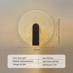 The Beautiful Wall Sconce, a gold circular wall light featuring a black center strip and a 19.5 cm diameter, exemplifies modern luxury with its contemporary and minimalist design. Made of hardware and acrylic with an LED 5W light source, it is suitable for a 90-260V power supply and illuminates an area of 3-5 sqm.