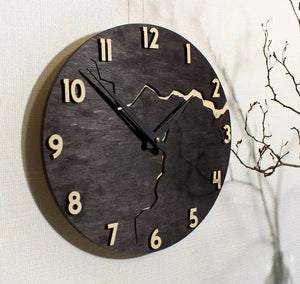 Featuring a unique jagged and wavy crack design in the center, the Wooden Round Wall Clock boasts a rustic modern aesthetic. Its natural wood finish perfectly enhances the bare branch on the right side, while the clock hands sit at ten and two for a striking broken effect.