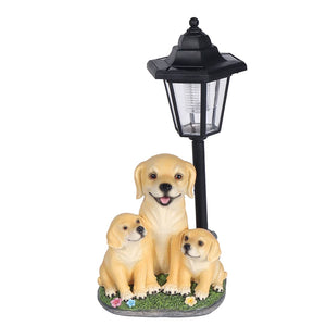 Solar Dog Light featuring a figurine of a dog and two puppies sitting on grass and flowers beside a vintage-style street lamp, capturing the charm of an old-fashioned outdoor porch light.