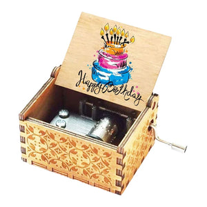 The Happy Birthday Music Box boasts a beautifully intricate carved design and presents a vibrant depiction of a cake and candles, accompanied by the "Happy Birthday" message inside the lid. Inside this exquisitely crafted wooden box, you'll find a visible hand-crank mechanism.