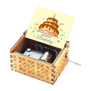 The Happy Birthday Music Box features intricate decorative carvings and opens to reveal a metal mechanism inside, accompanied by a card displaying a birthday cake and the text "Happy Birthday.