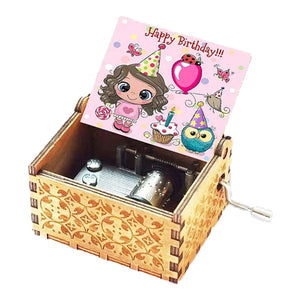 The Happy Birthday Music Box comes with engraved patterns and a hand crank, showcasing an open lid that reveals a vibrant "Happy Birthday" card adorned with cartoon characters in party hats.