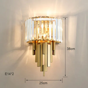 The Luxury Geometric Wall Sconce, designed in an Art Deco style with gold and crystal, features two E14 bulbs and measures 25cm wide by 38cm tall. It casts a warm glow against a neutral wall, enhancing any space with its elegant home decor appeal.