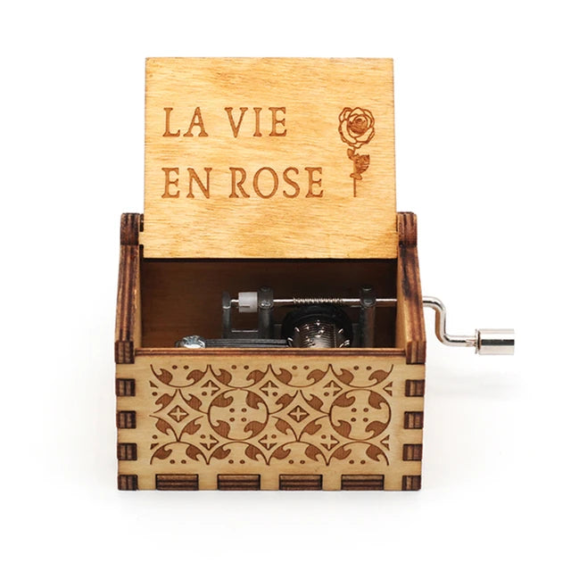 A Wooden Music Box with intricate designs and a hand crank, featuring the words "LA VIE EN ROSE" and a rose engraving on the lid. This beautifully handmade music box plays classic tunes, making it an enchanting keepsake.
