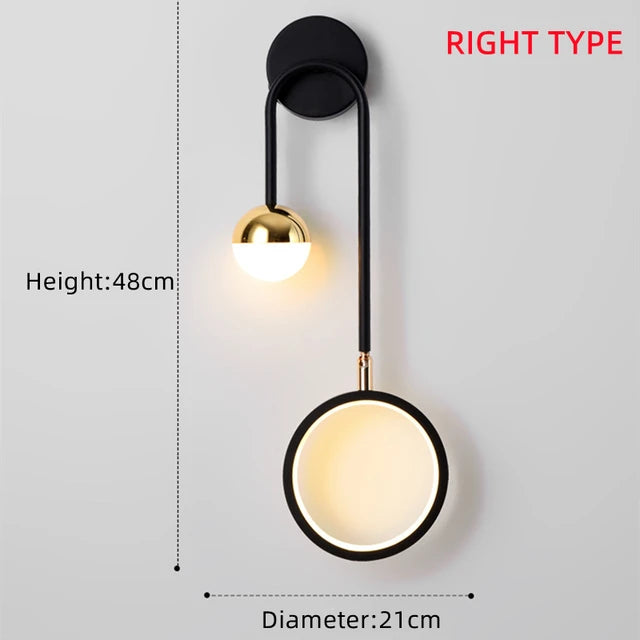 The Hanging Circle Wall Light boasts a modern design with a right-side configuration, featuring a black metal arm and two light sources. One light is a small sphere accented with gold, while the other is a larger circle, both showcasing elegant Nordic geometric shapes. It measures 48cm in height and has a diameter of 21cm.