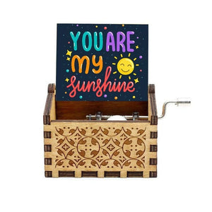 The "Music Box - You Are My Sunshine" is a wooden music box with a hand crank, featuring a card that reads "You Are My Sunshine" in colorful letters, making it the perfect Romantic Rotary Handle Music Box for any special occasion.