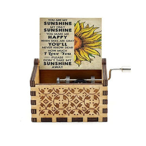 Music Box - You Are My Sunshine with an ornate design, featuring an open lid that displays the words "You Are My Sunshine" alongside a sunflower illustration. A hand crank is visible on the side.