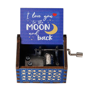 A blue wooden "Music Box - You Are My Sunshine" with an open lid displays the words "I love you to the moon and back," accompanied by a crescent moon illustration. This romantic rotary handle music box features a metal crank mechanism.