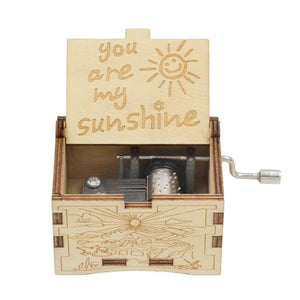 A small wooden music box, titled "Music Box - You Are My Sunshine," has an engraving of "You Are My Sunshine" on its open lid, revealing the internal mechanism.