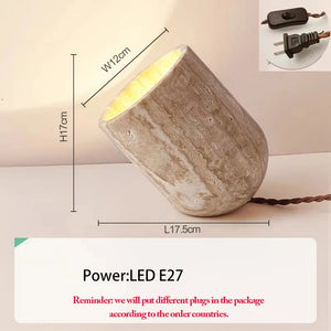 The Natural Stone Lamp is a sculptural table lamp with a stone-textured finish. Its dimensions are clearly labeled: height 17 cm, diameter 12 cm, and length 17.5 cm. The lamp features close-up images of the switch and plug for added detail and operates with an LED E27 bulb.
