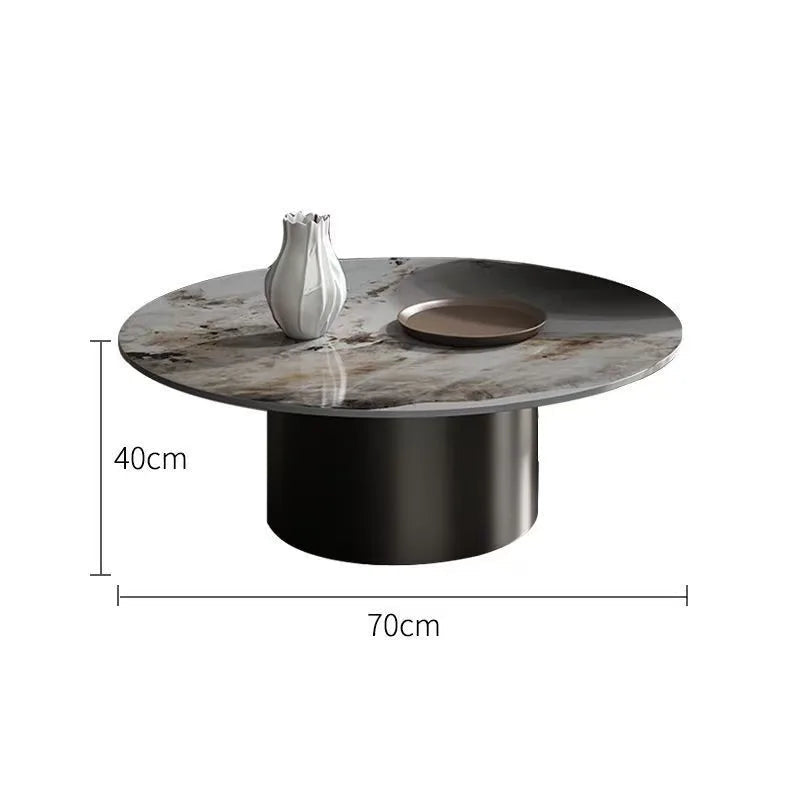 The Premium Round Coffee Table features a black cylindrical base and measures 70cm wide by 40cm tall. Styled with a decorative vase and plate, it's an ideal centerpiece for modern living spaces.