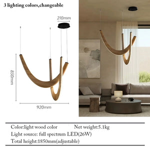 The Double Curve Wood Pendant Light, featuring a curved wood design, hangs above a neutral living room; its dimensions and specifications are shown next to the handcrafted wooden fixture.