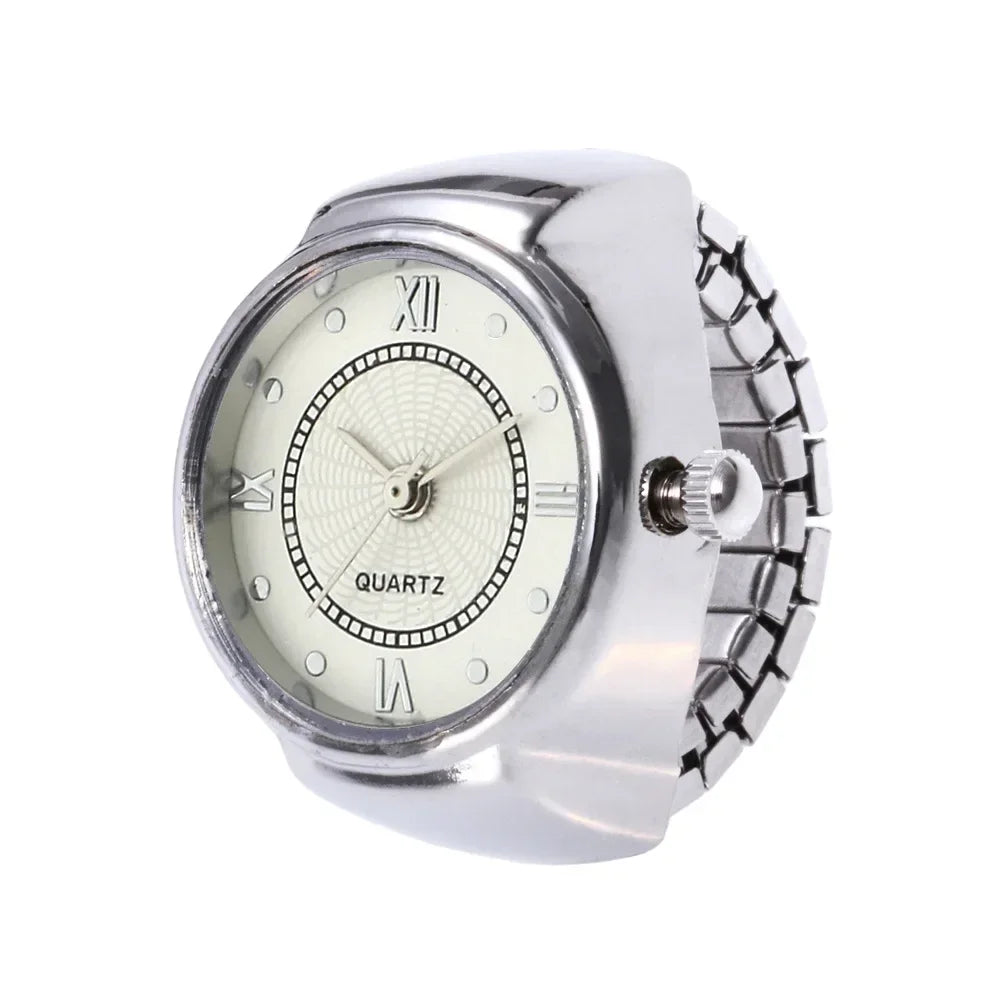 The Eternal Ring Watch is a silver ring with a small analog quartz clock face, Roman numerals, and a metal stretch band—ideal for those who love unique jewelry watches.