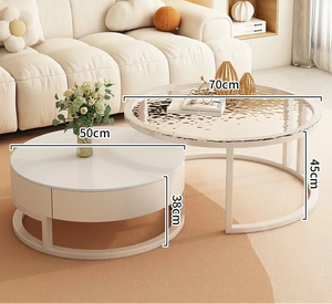 The Luxury Round Coffee Table Set includes a white marble-look table (50 cm wide, 38 cm tall) and a silver table (70 cm wide, 45 cm tall), both elegantly featured in a modern living room.