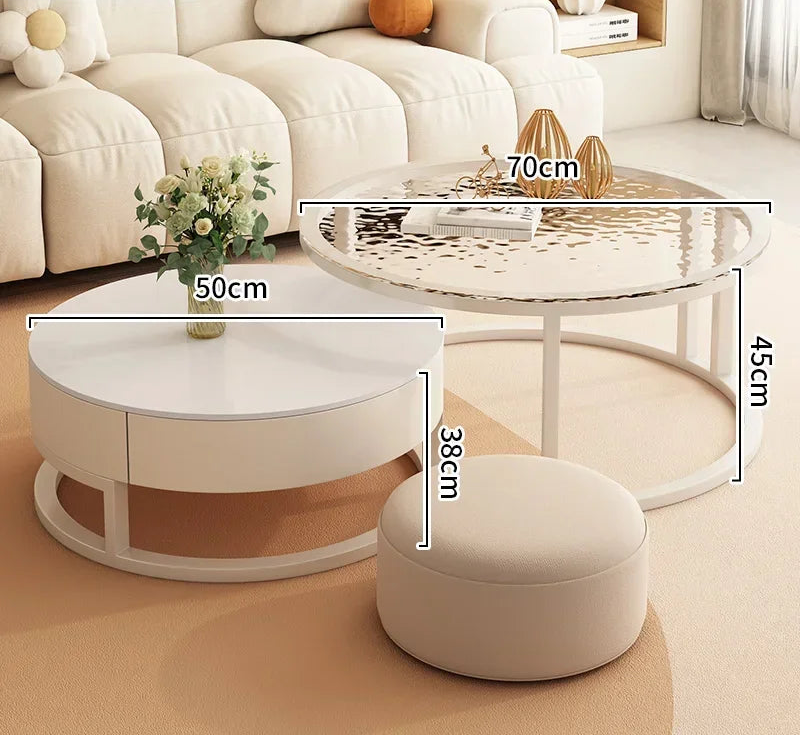 The beige living room is enhanced by the Luxury Round Coffee Table Set, which includes modern marble-look tables with a reflective top and drawer, as well as a matching round ottoman for added style.