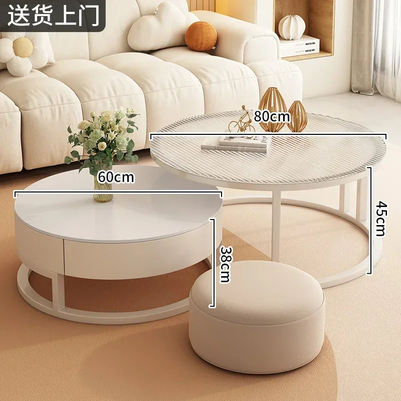The Luxury Round Coffee Table Set, featuring two minimalist round tables (80x45cm and 60x38cm) and a round ottoman, is placed in front of a cream sofa.