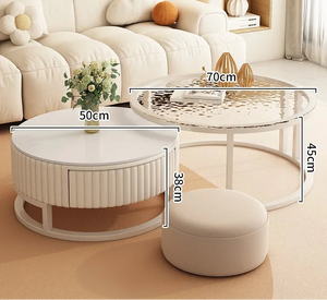 The Luxury Round Coffee Table Set, featuring two minimalist round tables of varying heights and diameters, is placed by a beige sofa with a small ottoman in front; both tables display labeled measurements.