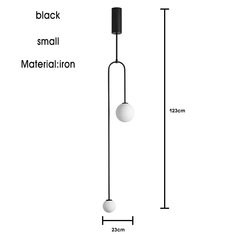 The Minimalist Line Light is a black, small iron pendant featuring two round white bulbs. It exemplifies modern lighting with its sleek design, standing at 123 cm tall and 23 cm wide, and incorporates a minimal mounting system.