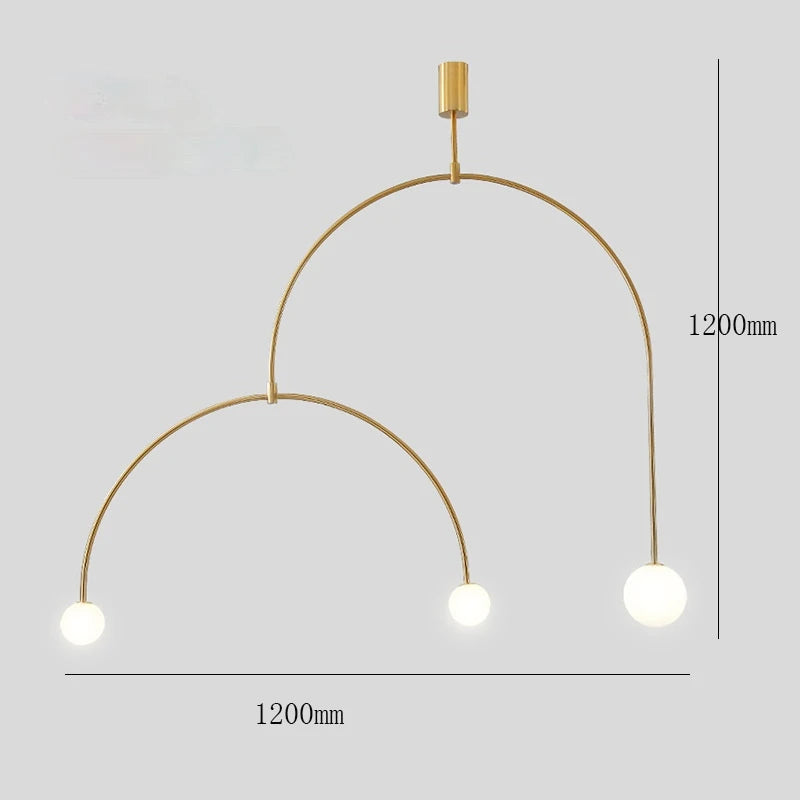 The Minimalist Line Light is a gold chandelier with two curved arms, featuring three spherical lights and a sleek mounting system. Measuring 1200mm by 1200mm against a light gray backdrop, it's an ideal choice for modern lighting enthusiasts.