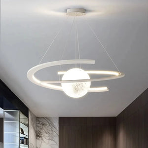 The Moon Trajectory Pendant Light features a spherical bulb and circular design, resembling an orbital chandelier. It hangs elegantly from the ceiling in minimalist spaces, offering advanced LED technology for efficient illumination.