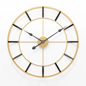 A large, minimalist decor enthusiast-approved wall clock with a gold frame and black hands against a white background.