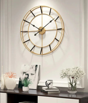 Large gold and black modern wall clock above a modern console table with minimalist decor.