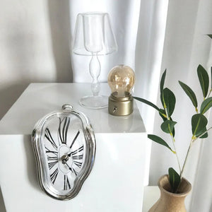 An artistically unique clock on a white cube.