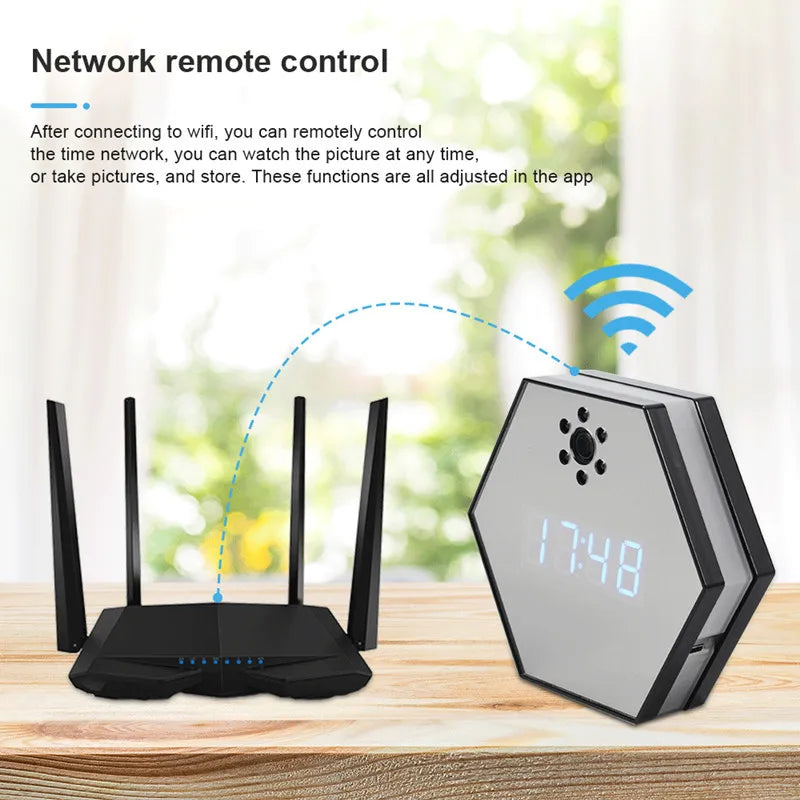 Digital Clock SpyCam with remote network control features, wireless router, and infrared night vision on a wooden table against a blurred window background.