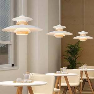 A Scandinavian-inspired dining room featuring a white table and chairs contrasted with natural wood accents, enhanced by a pendant light.