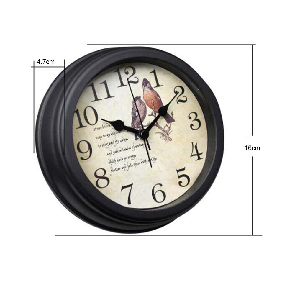 The Bird Clock SpyCam is a round wall clock with a black frame, featuring a bird and music notes illustration on the face. It includes night vision, black Arabic numerals and hands, measuring 16 cm in diameter and 4.7 cm in depth.